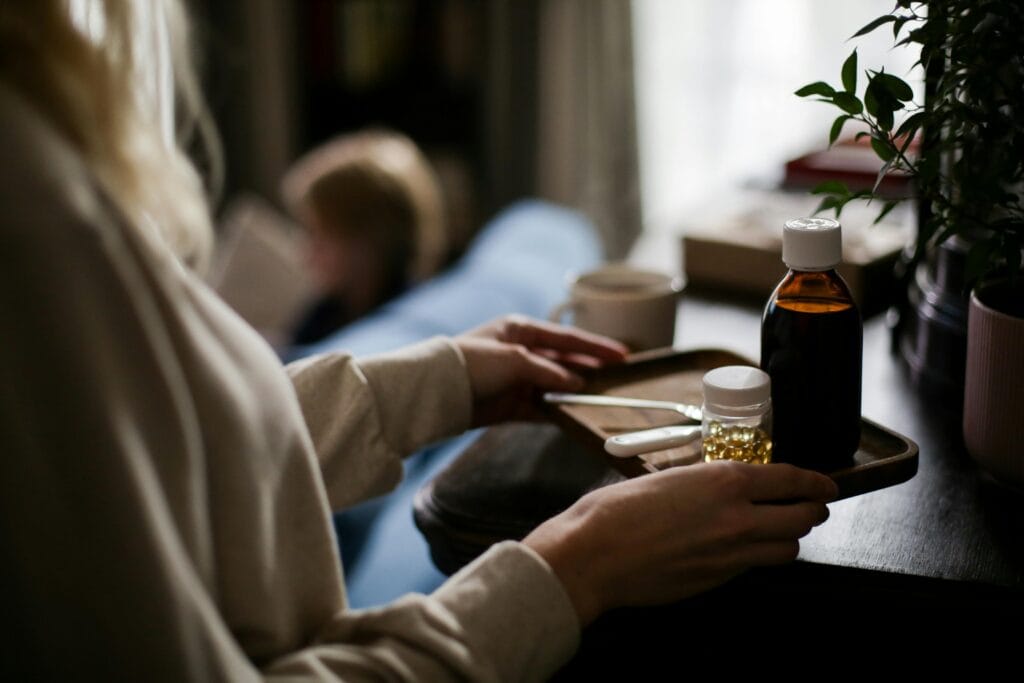 Close-up of a tray with various medicines and a thermometer indoors, suggesting home healthcare.